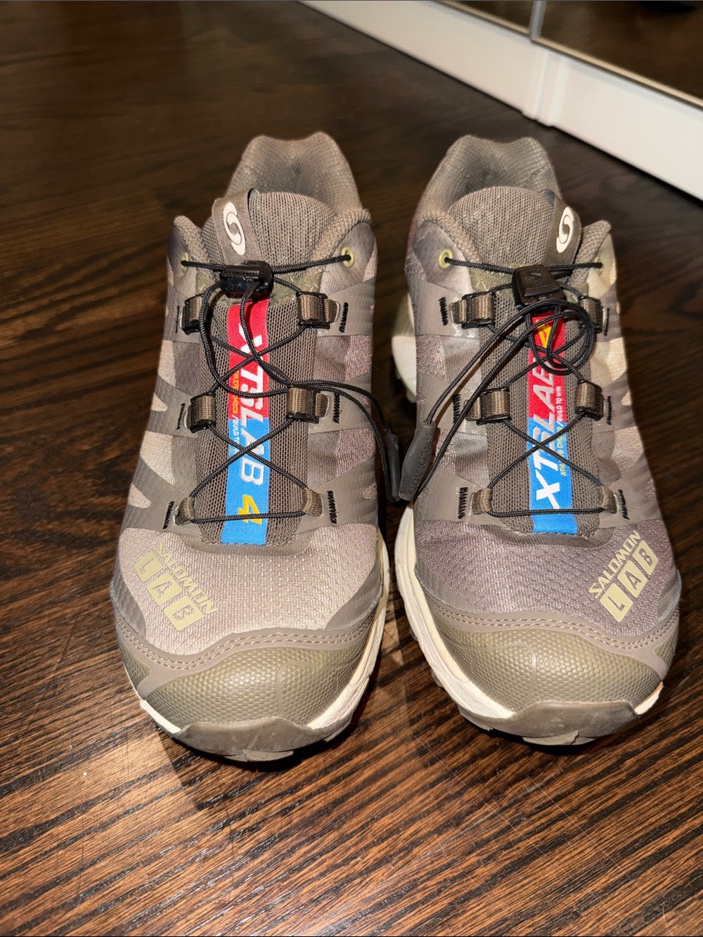 Salomon trail shoes in olive green with blue and red accents